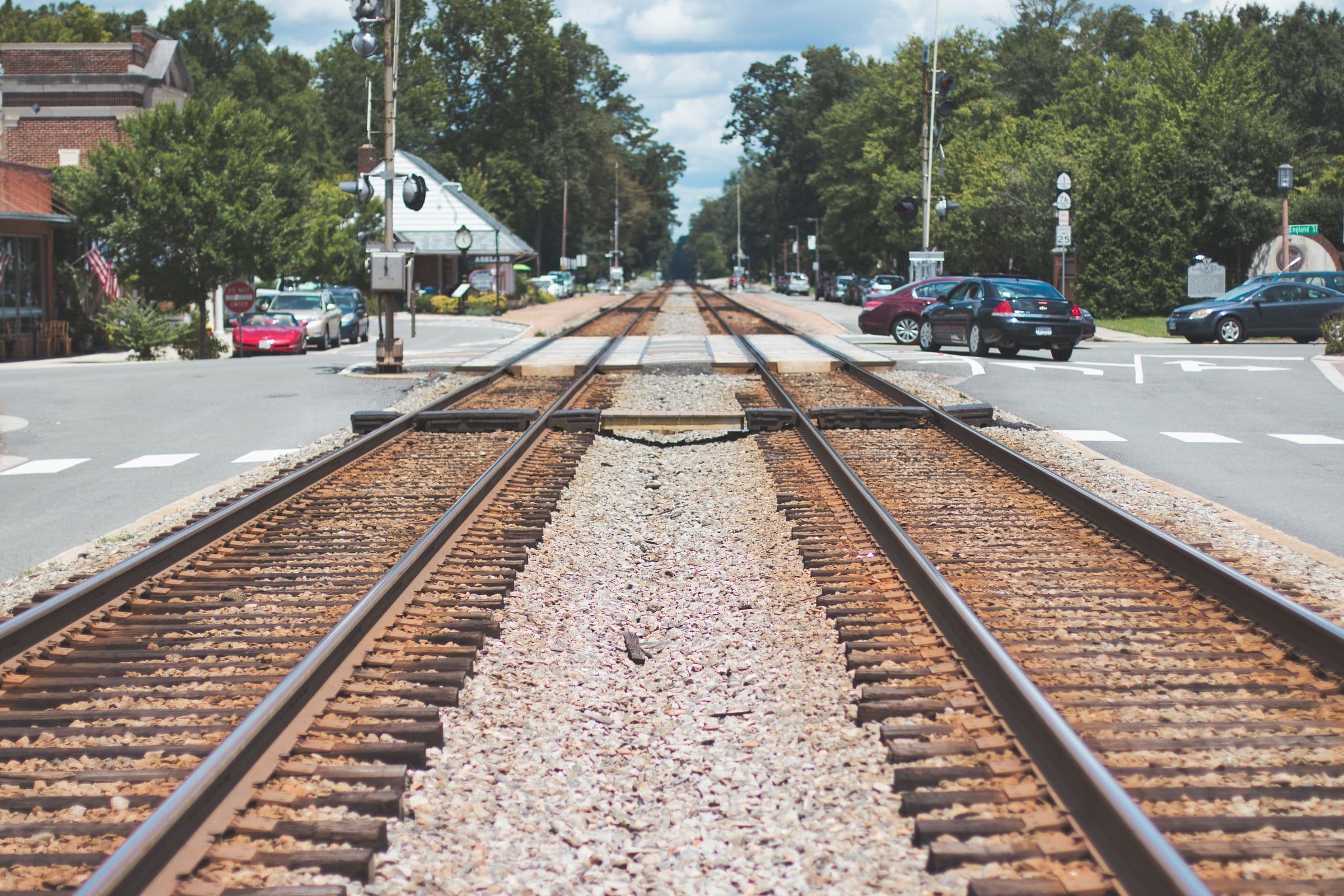 Railroad tracks crossing a small-town road lined with trees in Stedman NC