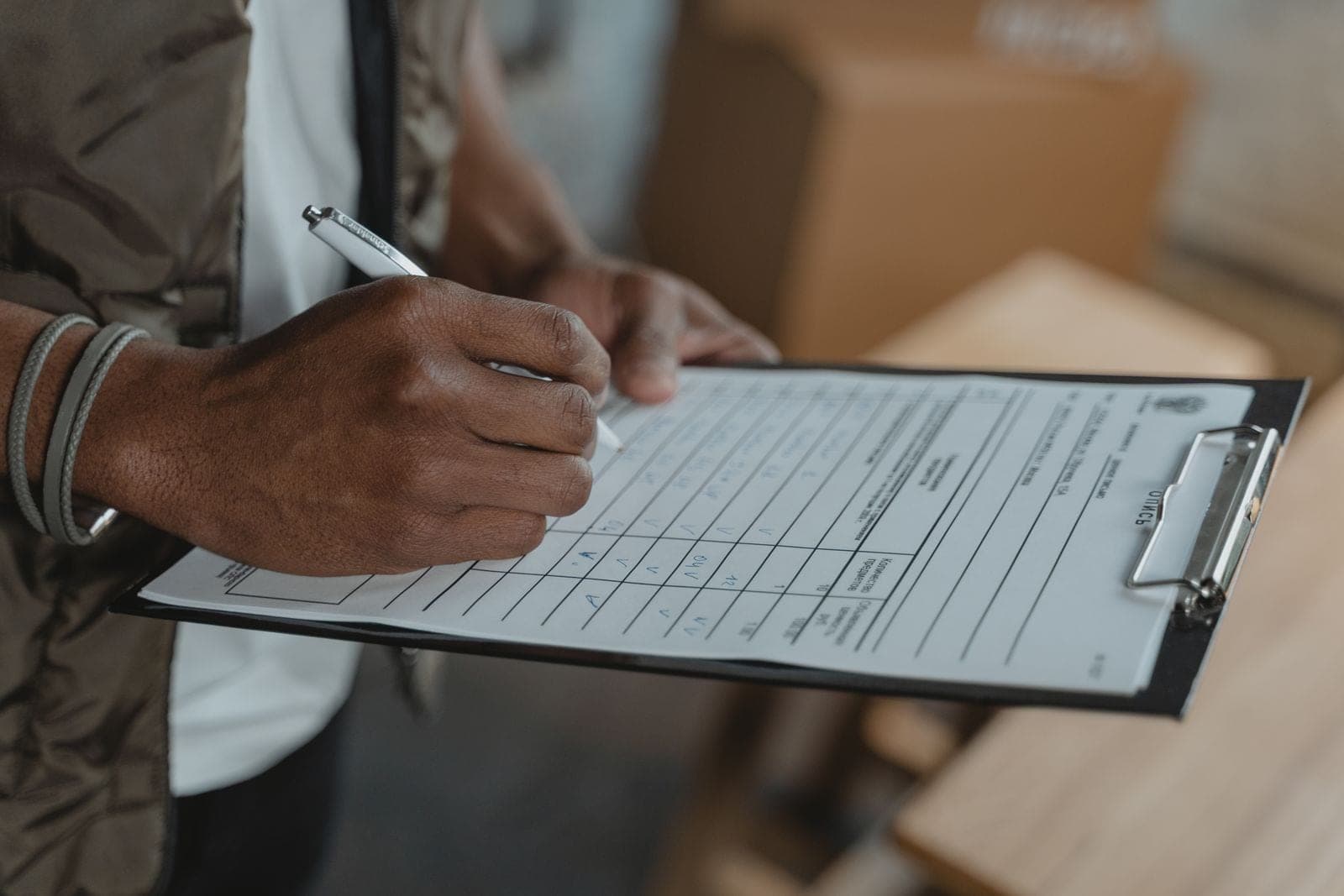 Hand filling in an estimate form on a clipboard