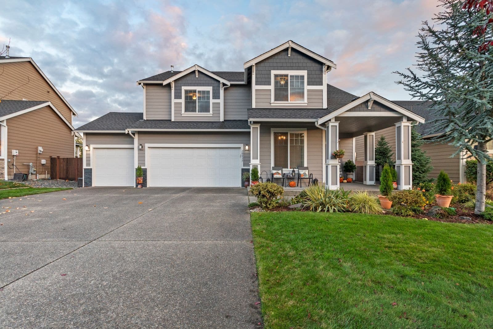 Two-story home with a three-car garage and a wide asphalt driveway